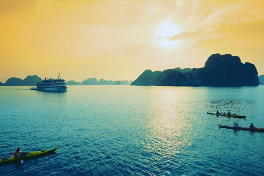 Tourists kayaking at sunrise near Halong Bay Cruise with Auasia Travel Vietnam